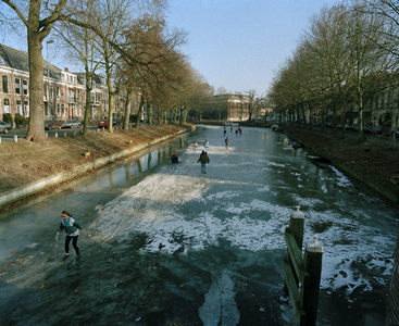 73499 Gezicht op de dichtgevroren Stadsbuitengracht met schaatsers te Utrecht, vanaf de Van Asch van Wijckbrug. Links ...